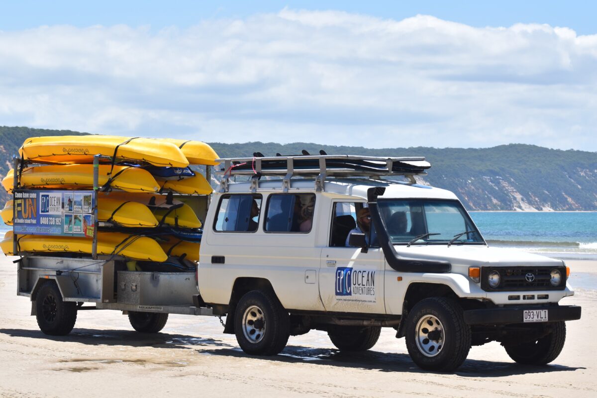 4X4 vehicle loaded with yellow kayaks on Rainbow Beach