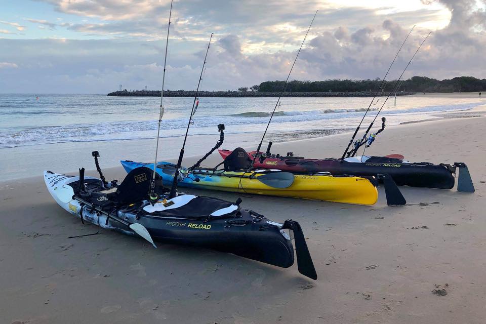 Viking fishing kayak parked on sandy beach with fishing gear