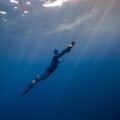 Freediver swimming deep with ASIWO U1 scooter